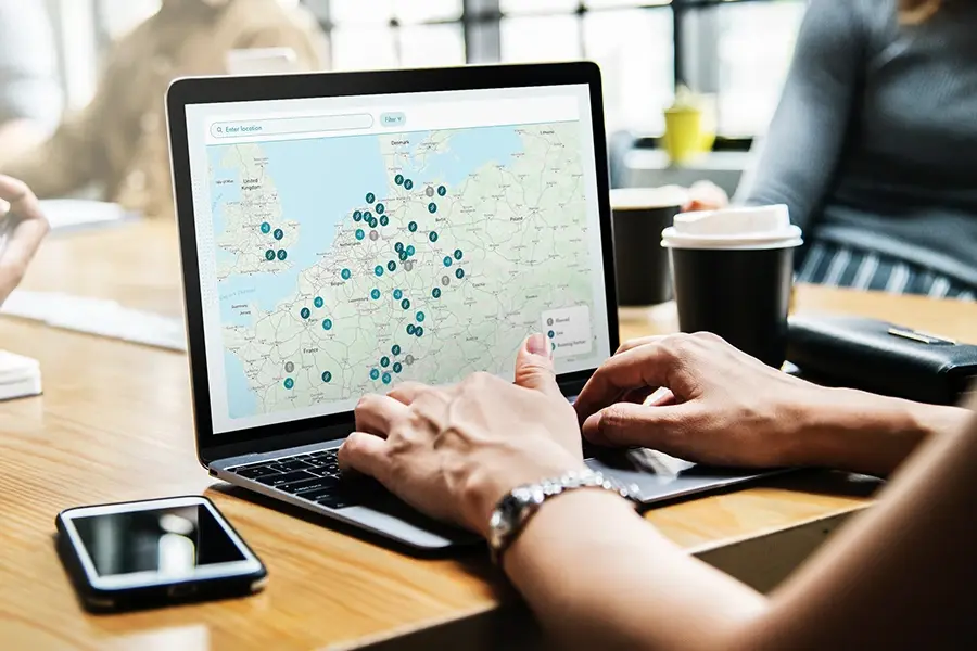 sbrs-related-topic-shell-recharge-map Zwei Ingenieure geben sich die Hand an einem Containerterminal