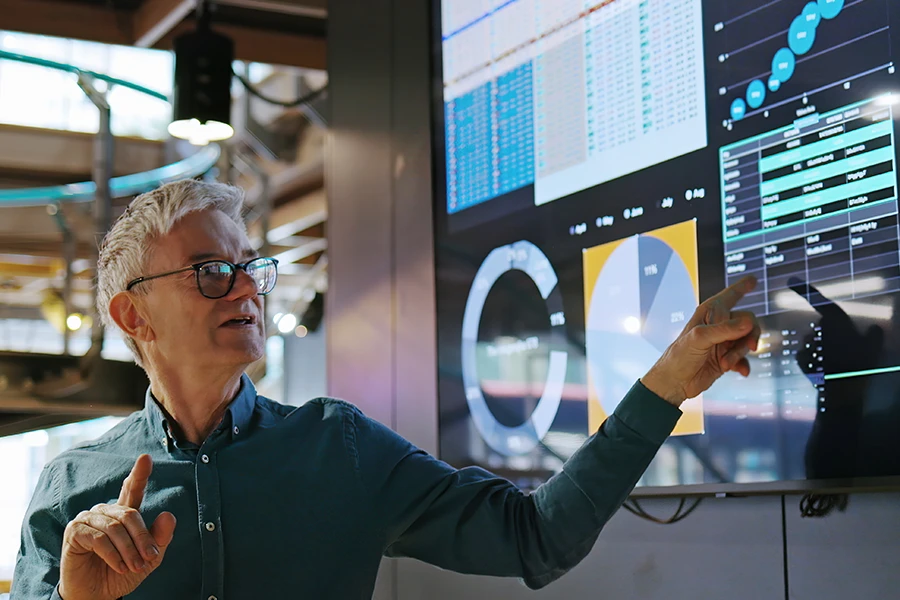 Person analyzing data dashboards on a large screen display