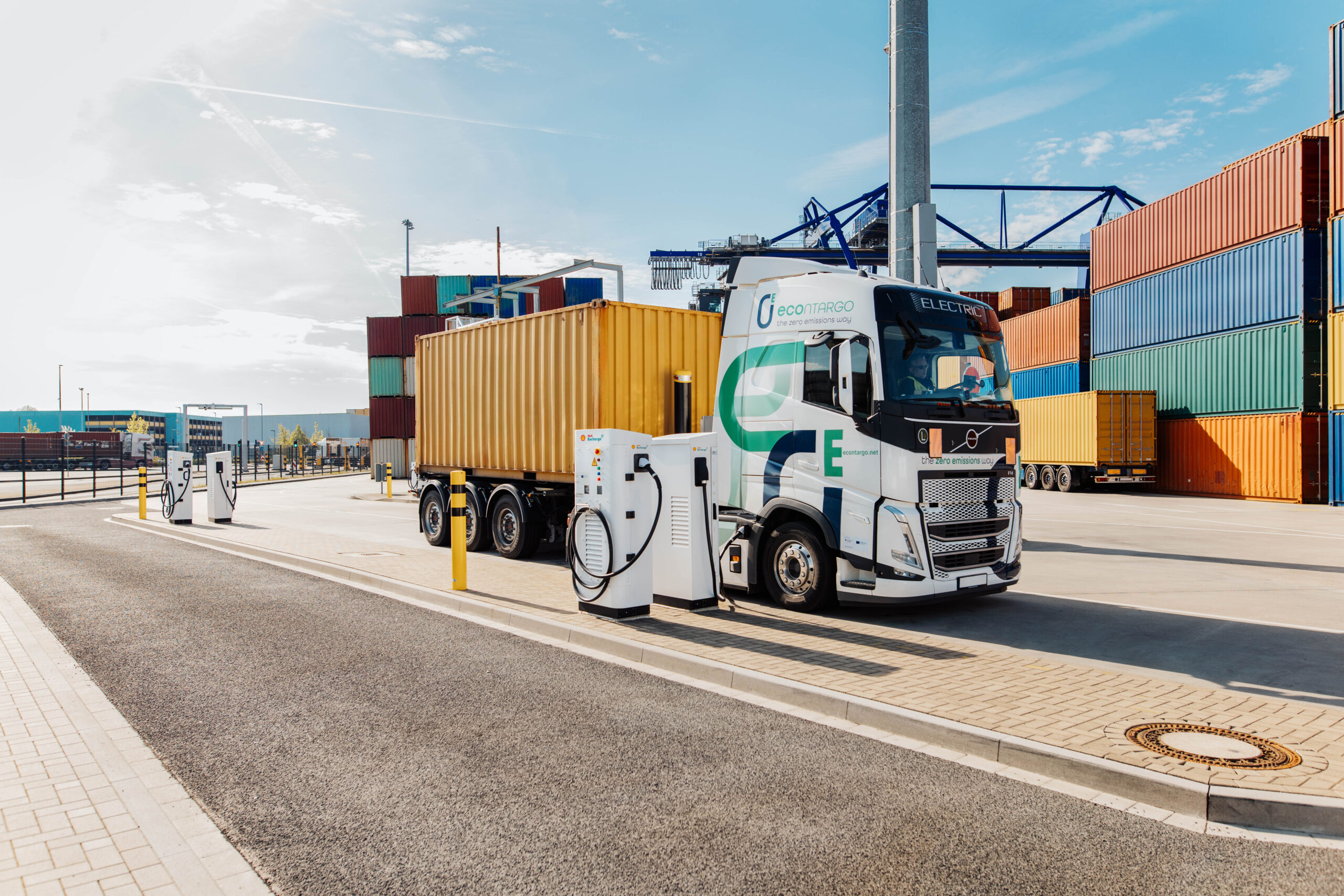 Electric Contargo truck charging at a high-performance charging station in a container terminal.