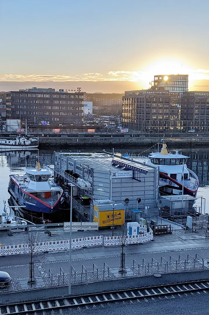 sbrs-industries-charging-for-electric-boats Electric boats docked at a harbor with adjacent containerized charging station at sunrise