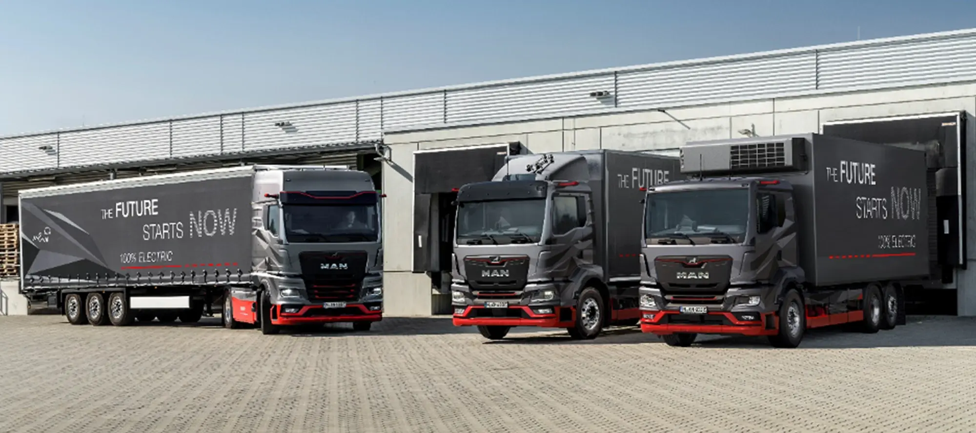 Drei Elektro-Lkw auf einem Logistikgelände abgestellt