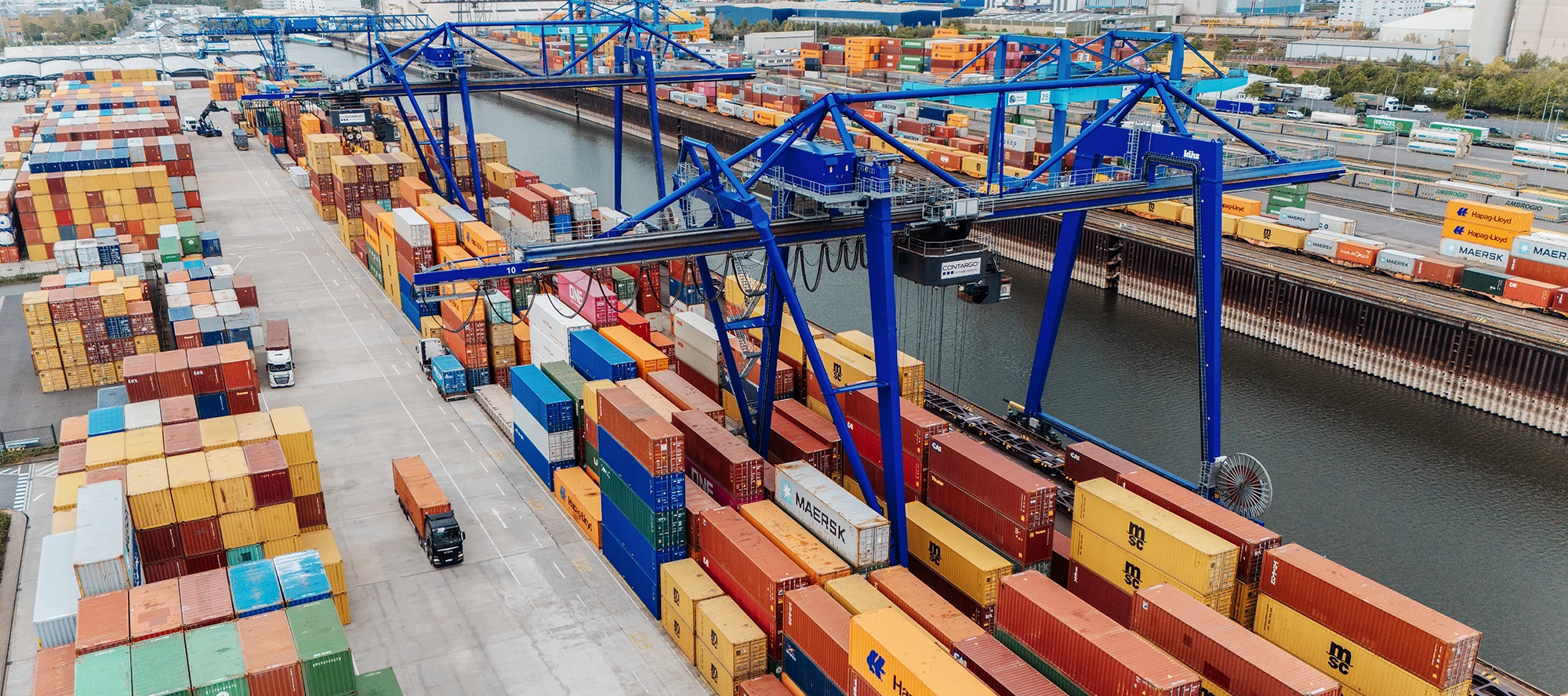 Container terminal in Neuss with colorful containers, large cranes and docked freight ships