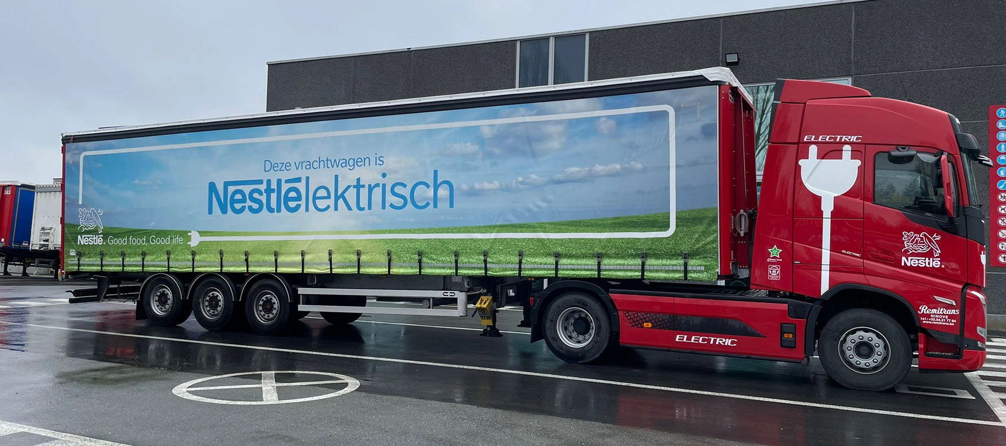 Roter Elektro-Lkw mit Nestlé-Auflieger, geparkt am Remitrans-Lade-Depot in Ath, Belgien.
