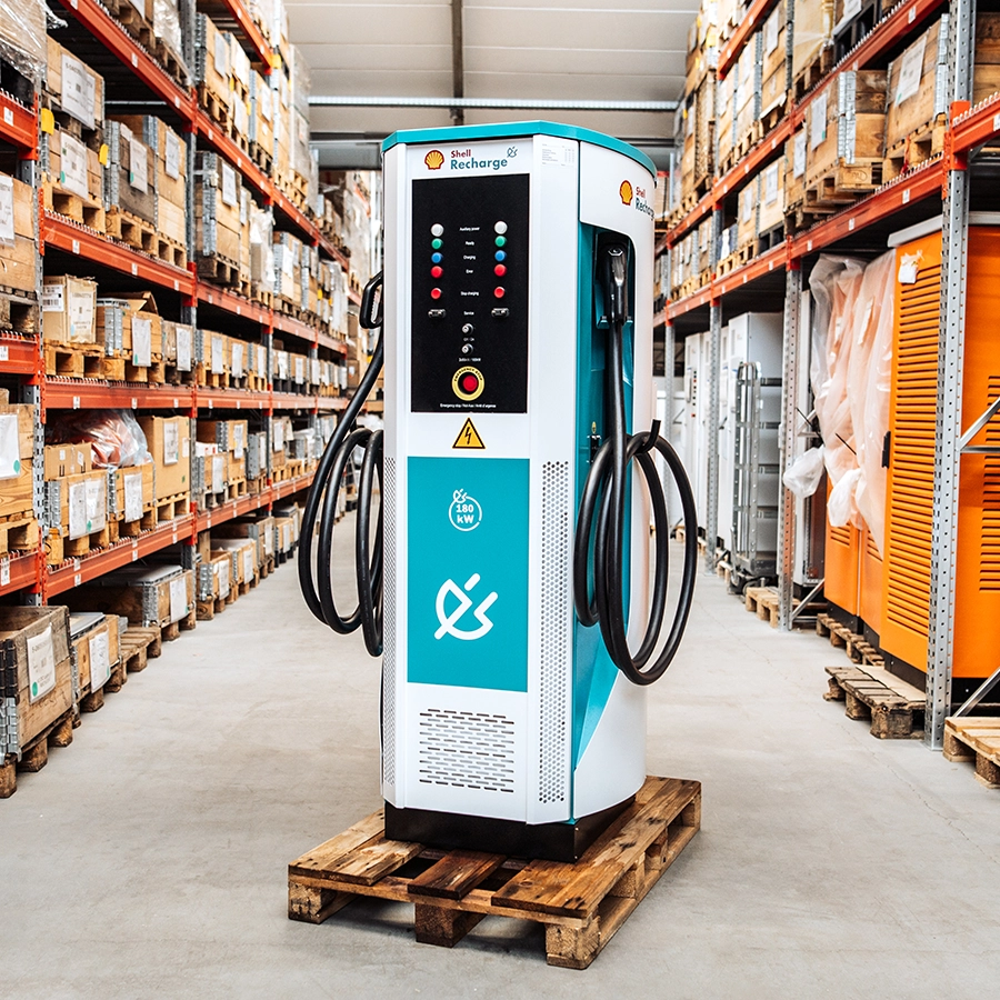 Angled side view of the Flex180 DC charging station shown in a warehouse environment on a wooden pallet.