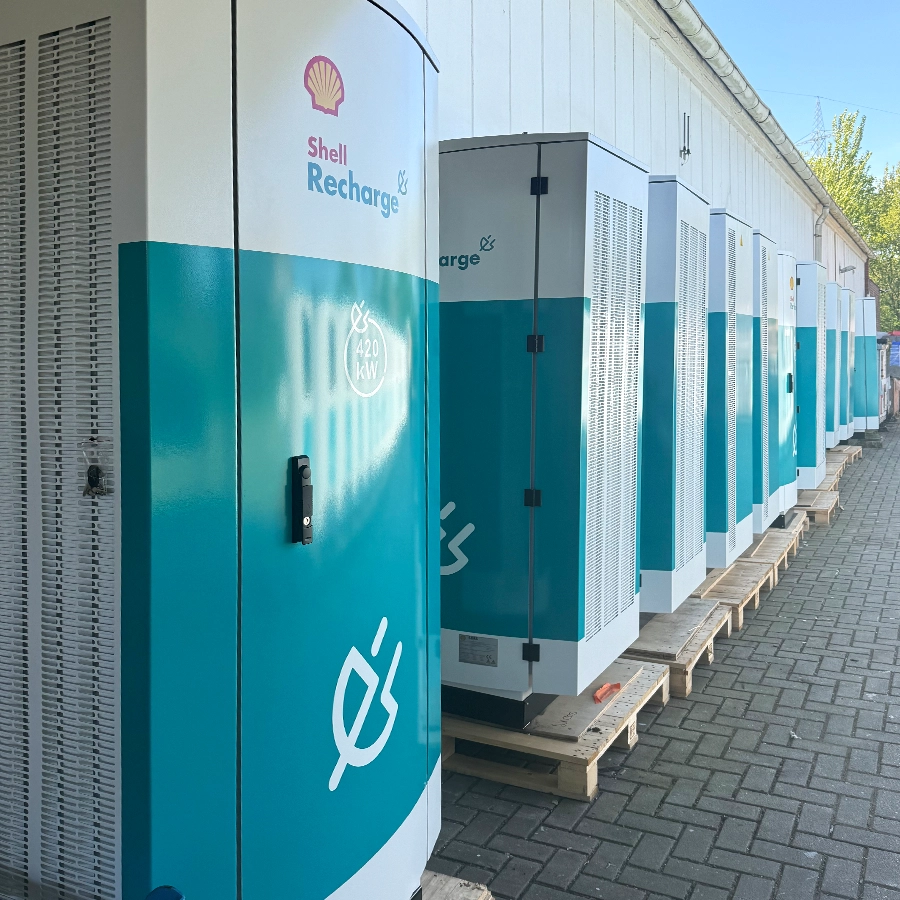 Row of MOCA high-power chargers lined up on wooden pallets outside a building