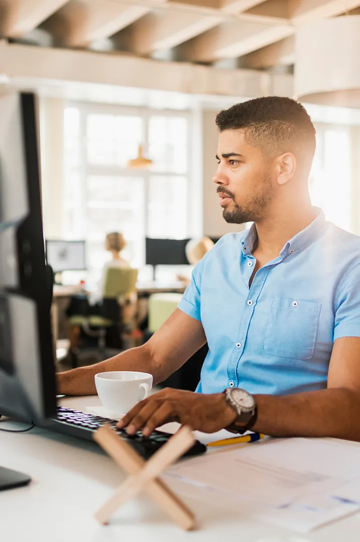 sbrs-solutions-services-solution-design-and-engineering Engineer working at a computer in a modern office – representing SBRS solution design and infrastructure planning.