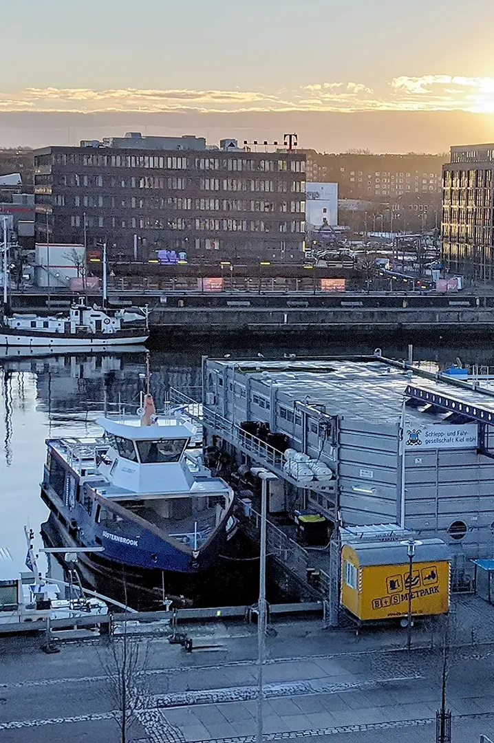 Elektroboot im Hafen mit Ladeinfrastruktur am Kai