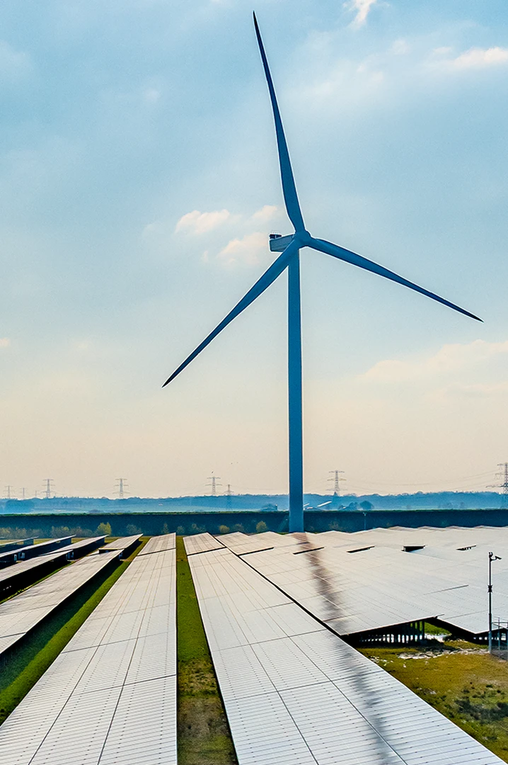 Windkraftanlage und Solarpaneele symbolisieren die erneuerbare Energieversorgung von SBRS für Unternehmen.